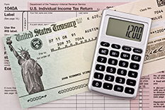 Tax forms, calculator, and a check from US treasury