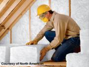 man installing insulation in attic