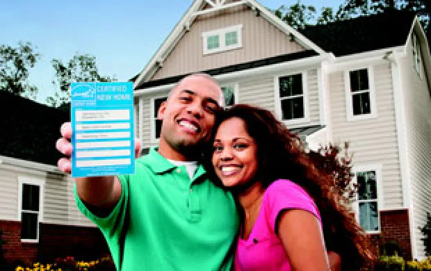 smiling couple holding a certified label