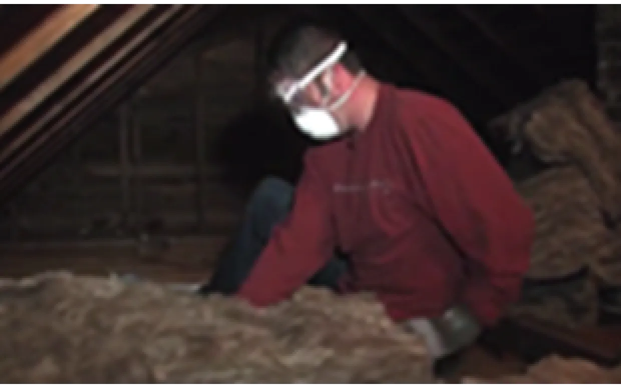 person insulating an attic