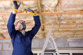 man installing insulation in a basement