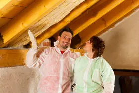 Couple installing thermal insulation